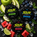 Flat lay of SOUR ENERGY Blue Razz Mint, Green Apple Ice and Watermelon Lime caffeine pouch tins with fresh fruit and ice